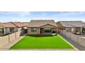 Well maintained backyard with artificial grass and block fence, perfect for relaxing and entertaining at 40990 W Agave Rd, Maricopa, AZ 85138