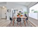 Dining room with modern table and seating, view to the kitchen, and natural light from the nearby window at 4445 W Oraibi Dr, Glendale, AZ 85308
