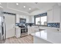 Well-lit kitchen with stainless steel appliances, white cabinets, and a window for natural light over the sink at 4445 W Oraibi Dr, Glendale, AZ 85308