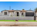 Inviting single-story home features crisp white exterior, contrasting trim, and a well-kept lawn at 4611 N 79Th Dr, Phoenix, AZ 85033