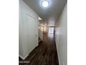 Entryway with dark vinyl floors leading to open-concept living area and staircase at 6339 W Sophie Ln, Laveen, AZ 85339