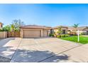 Spacious home with a three-car garage, expansive driveway, and desert landscaping at 6808 W Angela Dr, Glendale, AZ 85308