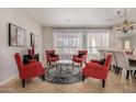 Cozy living area features four red chairs and a round glass coffee table at 6808 W Angela Dr, Glendale, AZ 85308