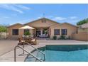 Inviting backyard with a pool, outdoor dining area, and a covered patio perfect for entertaining at 8210 W Wethersfield Rd, Peoria, AZ 85381