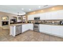 Spacious kitchen with stainless steel appliances, white cabinets, and a view into the living room at 8210 W Wethersfield Rd, Peoria, AZ 85381