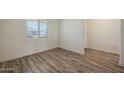 Bright bedroom with wood-look flooring, white walls, and a large window at 1131 W West Virginia Ave, Florence, AZ 85132