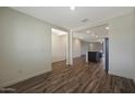 Open-concept living space with modern wood-look flooring and neutral paint at 1131 W West Virginia Ave, Florence, AZ 85132