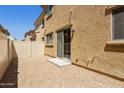 Small gravel backyard with a beige privacy fence and sliding glass door at 1367 S Country Club Dr # 1167, Mesa, AZ 85210