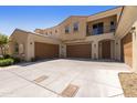 Beige two-story home with brown garages, balcony, and a spacious concrete driveway at 1367 S Country Club Dr # 1167, Mesa, AZ 85210