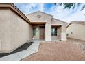 Close-up of front door entry with charming stucco wall and neutral desert landscaping at 14752 W Evans Dr, Surprise, AZ 85379