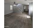 Spacious living room with plush carpet, staircase, and bright lighting at 15446 W Jenan Dr, Surprise, AZ 85379