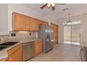 Functional kitchen featuring wooden cabinets, stainless steel appliances, and access to an outdoor area at 15806 N 107Th Pl, Scottsdale, AZ 85255