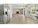 Open-concept living area featuring wood-style floors and a cozy brick fireplace with stainless appliances in kitchen at 1741 S Clearview Ave # 74, Mesa, AZ 85209