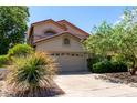 Inviting home with a two-car garage, complemented by lush greenery and mature landscaping for enhanced curb appeal at 21614 N 59Th Ln, Glendale, AZ 85308