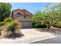 Inviting home with a two-car garage, complemented by lush greenery and mature landscaping for enhanced curb appeal at 21614 N 59Th Ln, Glendale, AZ 85308