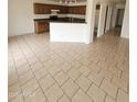 Open-concept kitchen and dining area featuring tile floors, a breakfast bar, and views of living room at 22872 W Gardenia Dr, Buckeye, AZ 85326