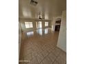 Bright living room with tile floors, ceiling fan, and sliding glass doors to the backyard at 22872 W Gardenia Dr, Buckeye, AZ 85326
