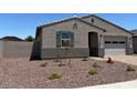 Charming single story home featuring a low maintenance rock yard, attached two car garage, and covered entryway at 24486 W Grenadine Rd, Buckeye, AZ 85326