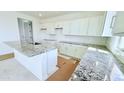 Bright kitchen with white cabinets, granite countertops, and a large island at 25130 N 156Th Ln, Surprise, AZ 85387