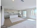 Spacious open-plan living room and kitchen area with tile flooring and lots of natural light at 25130 N 156Th Ln, Surprise, AZ 85387