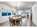 Bright open-concept living space with wood floors, modern lighting and large windows at 3010 W Laredo Ln, Phoenix, AZ 85085