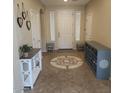 Inviting entryway with decorative tile inlay, console table, and shoe storage for organized living at 42160 W Arvada Ct, Maricopa, AZ 85138
