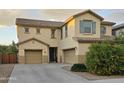 Inviting two-story home with a three-car garage, neutral stucco, and low-maintenance landscaping at 42160 W Arvada Ct, Maricopa, AZ 85138