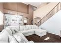 Spacious living room features a large sectional sofa and staircase at 42160 W Arvada Ct, Maricopa, AZ 85138