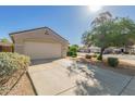 Well-maintained one-story home with a long driveway, two-car garage and tidy desert landscaping at 8104 S 73Rd Dr, Laveen, AZ 85339