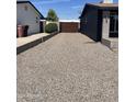 Back driveway with stone landscaping, enclosed by a wooden back gate, and bordering homes at 8520 E Mackenzie Dr, Scottsdale, AZ 85251