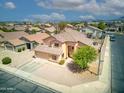 An aerial of a tan house in a quiet neighborhood, highlighting its well-kept lawn and landscaping at 10308 E Osage Ave, Mesa, AZ 85212