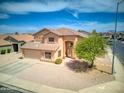 Aerial view of a well-maintained tan house with a two-car garage and desert landscaping at 10308 E Osage Ave, Mesa, AZ 85212