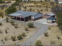 Aerial view of a home on a large lot, featuring a long driveway and multiple outbuildings at 10622 N Malachite Way, Casa Grande, AZ 85122
