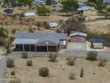 Aerial view of a rural property with a single-story home, large driveway and separate storage buildings at 10622 N Malachite Way, Casa Grande, AZ 85122