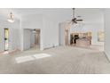 Bright living area with neutral carpet, ceiling fan, and an open layout adjacent to the kitchen at 11405 W Windsor Ave, Avondale, AZ 85392