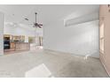 Spacious living room featuring neutral carpeting, high ceilings, and views into the eat-in kitchen at 11405 W Windsor Ave, Avondale, AZ 85392