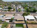 Aerial view showcases a neighborhood with mature trees and a glimpse of the city skyline in the distance at 1320 E Butler Dr, Phoenix, AZ 85020