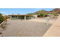 Single story home features an arid front yard and a covered driveway, with mountain views at 1320 E Butler Dr, Phoenix, AZ 85020