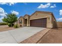 Charming single-story home featuring a two-car garage, neutral stucco, and desert landscaping at 16938 N Verde Pl, Maricopa, AZ 85138