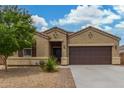 Charming single-story home featuring a two-car garage, desert landscaping, and a brick-lined walkway at 16938 N Verde Pl, Maricopa, AZ 85138