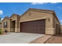 Single-story home featuring a two-car garage, brick-lined walkway and neutral stucco at 16938 N Verde Pl, Maricopa, AZ 85138