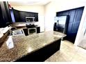 Kitchen featuring granite counters, stainless steel appliances, and dark cabinets at 18166 W Camino Real Dr, Surprise, AZ 85374