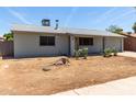Single-story home with a light gray paint, minimal landscaping, and a two-car garage at 18427 N 32Nd Ln, Phoenix, AZ 85053