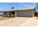 Single-story home with attached two-car garage, a long driveway, and minimal landscaping at 18427 N 32Nd Ln, Phoenix, AZ 85053