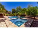 The pool and spa are surrounded by attractive hardscape and lush tropical landscaping at 30135 N 129Th Gln, Peoria, AZ 85383