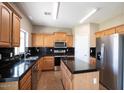Well-equipped kitchen with stainless steel appliances, dark countertops, and stylish cabinetry at 30375 W Verde Ln, Buckeye, AZ 85396