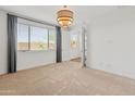 A bright and spacious bedroom with neutral carpet and a stylish light fixture at 3264 W Caleb Rd, Phoenix, AZ 85083