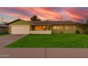 Beautiful one-story home with a lush green lawn, mature landscaping, and an attached two-car garage at 4004 W Myrtle Ave, Phoenix, AZ 85051