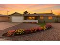 Charming one-story home featuring colorful flower beds, a well-maintained gravel yard, and a two-car garage at 4004 W Myrtle Ave, Phoenix, AZ 85051