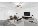 Bright living room featuring neutral furniture, a ceiling fan, and a decorative marbled floor at 4004 W Myrtle Ave, Phoenix, AZ 85051